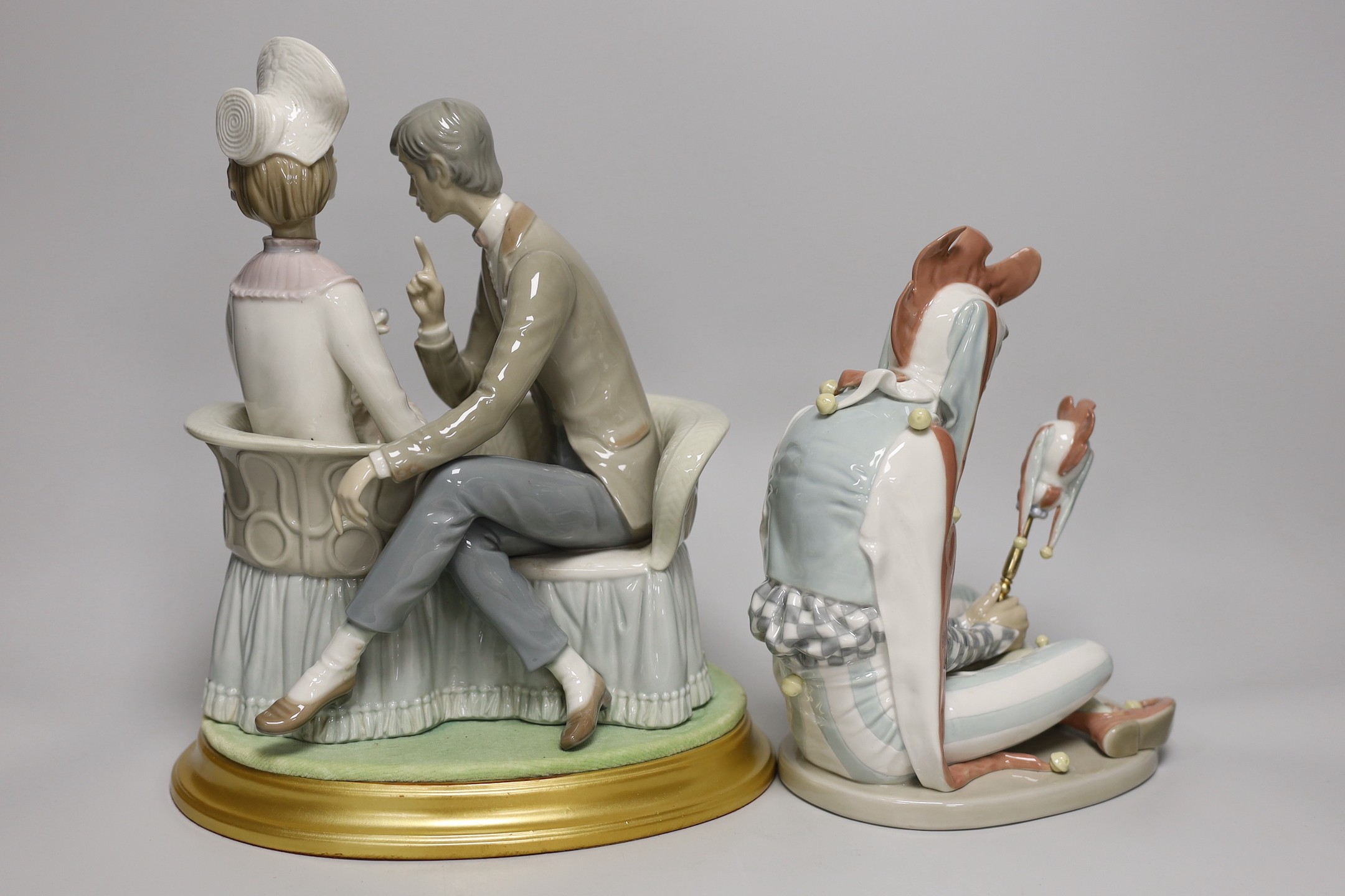 A large Lladro figure group of a couple and their dog on base together with a Lladro figure of a kneeling jester. Tallest 29cm
